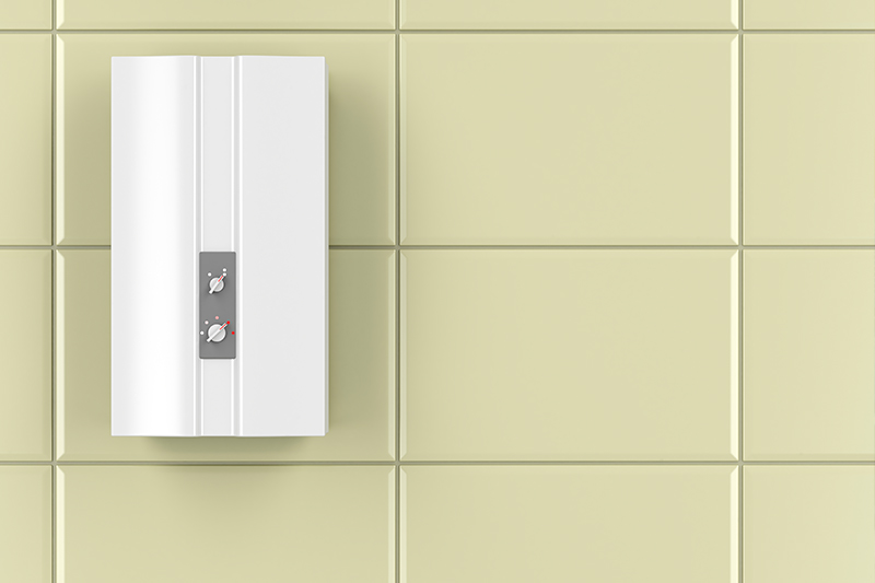 A white tankless water heater hanging in tiles wall.